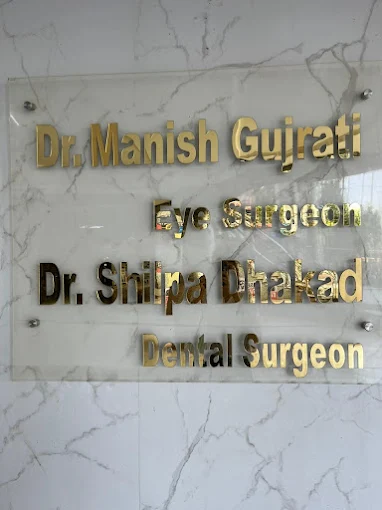 Clinic name board displaying Dr. Shilpa Dhakad Dental Surgeon and Dr. Manish Gujrati Eye Surgeon.
